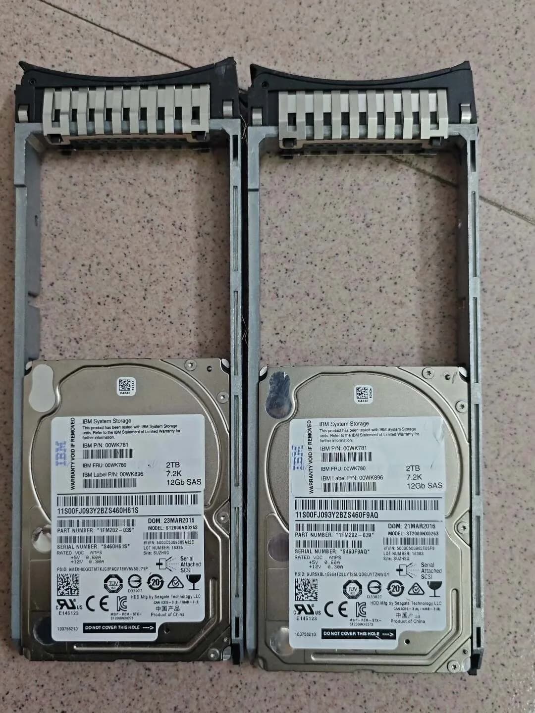 Two IBM System Storage 2TB SAS drives in carriers with 00WK780 and 00WK781 labels
