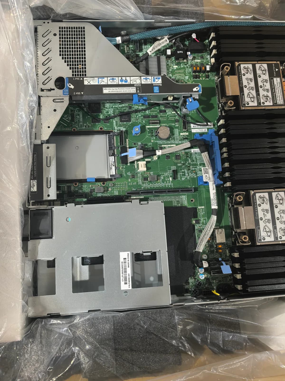 HPE rack server interior showing motherboard slots, cables, risers and drive-bay area